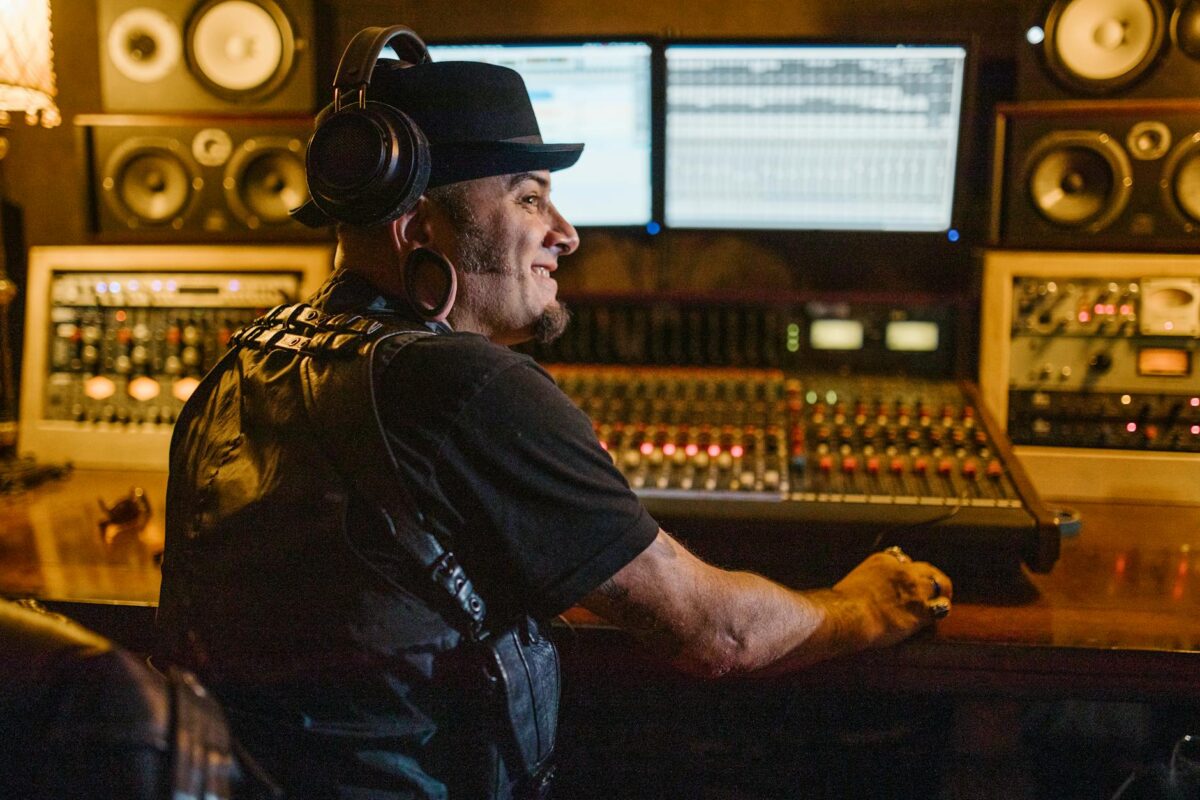 man in hat at desk with music equipment